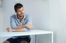 young-hispanic-male-wearing-blue-shirt-posing-white-desk