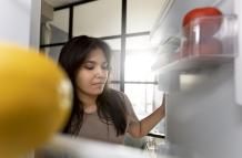 woman-checking-interior-her-fridge-home