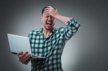 portrait-young-handsome-man-using-laptop-wearing-plaid-shirt-studio-shot-emotions