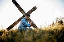 shallow-focus-shot-male-carrying-handmade-cross