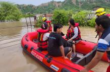 Inundaciones en San Clemente debido al temporal invernal en Manabí, con familias evacuadas por bomberos en lanchas.