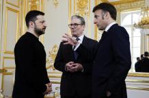 El presidente de Ucrania, Volodymyr Zelensky (I), el primer ministro británico, Keir Starmer (C), y el presidente de Francia, Emmanuel Macron, conversan durante una reunión trilateral al margen de la cumbre de la 'Coalición de los Dispuestos' en el Palaci