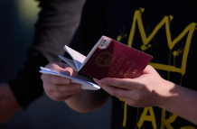 Un migrante sostiene su pasaporte para ser inspeccionado por la Patrulla Fronteriza de EE. UU.
