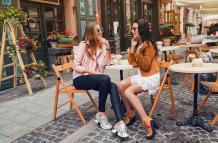 dos-mujeres-jovenes-con-estilo-sentado-en-el-cafe