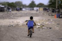 Un niño migrante venezolano monta su bicicleta en el campamento de migrantes La Pista en Maicao, departamento de La Guajira, Colombia, el 22 de abril de 2025.