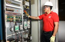 Un trabajador da mantenimiento eléctrico a una planta industrial