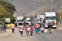 Personas caminan por una carretera en  Cochabamba (Bolivia).