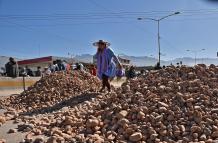 mujer captada al pasar sobre un montículo de piedras en Cochabamba (Bolivia).