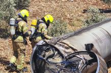 Dos bomberos observan los restos de un misil balístico iraní en un olivar de Galilea.
