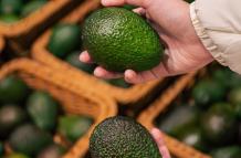 una-mujer-elige-un-aguacate-en-una-tienda-de-comestibles