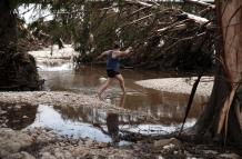 mujer cruza una sección del río Guadalupe,