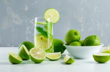 limonada-en-un-vaso-con-limones-hierbas-vista-lateral-en-blanco-y-yeso