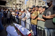 Personas rezan tras la llegada de muertos en Gaza