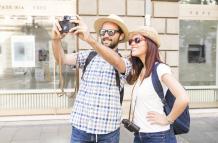 pareja-con-gafas-de-sol-y-sombrero-tomando-selfie-en-camara