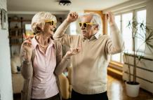 alegre-pareja-de-ancianos-con-gafas-de-sol-bailando-y-divirtiendose-juntos-en-casa