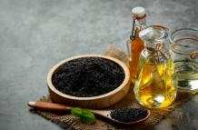 aceite-de-sesamo-y-semillas-de-sesamo-negras-crudas-sobre-fondo-oscuro