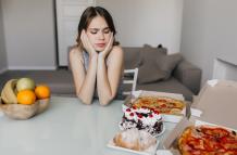 triste-mujer-rizada-mirando-pastel-durante-la-dieta-modelo-de-mujer-hermosa-rubia-posando-con-frutas-y-pizza