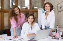 grupo-de-jovenes-mujeres-alegres-con-laptop-felizmente-mirando-en-camara