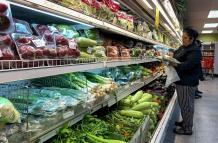 Una mujer compra alimentos en un supermercado.