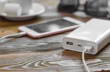powerbank-y-telefono-movil-en-mesa-de-madera