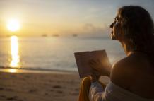 mujer-leyendo-en-la-vista-lateral-de-la-playa