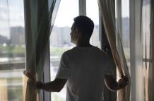 retrato-creativo-del-hombre-con-cortinas-y-sombras-desde-la-ventana