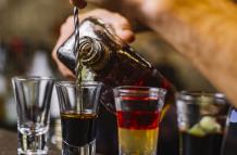 vista-lateral-de-bebidas-alcoholicas-multicolores-licor-con-una-rodaja-de-kiwi-sobre-la-mesa