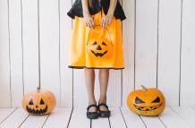 piernas-de-nina-sosteniendo-la-cesta-de-halloween-con-calabazas-en-los-lados
