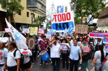 Ciudadanos portan banderas tricolor y pancartas con el mensaje “Nones” durante el cierre de campaña en Guayaquil.