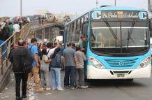Personas hacen fila para subir a un bus en Perú