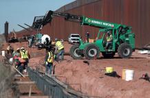 Obreros estadounidenses construyen un muro fronterizo