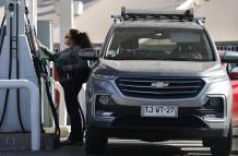 Una persona abastece de combustible un vehículo