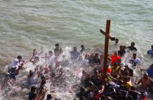 Entre plegarias y cánticos los pescadores de Ballenita bañaron la cruz