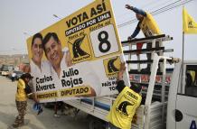 Personas sostienen una valla publicitaria Perú