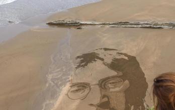 El artista peruano Germán Cedano trabaja en una playa del norte de España.