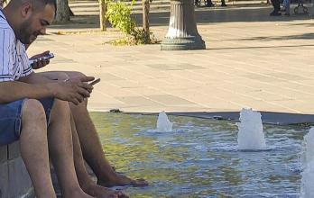 Varias personas se remojan en una fuente ornamental