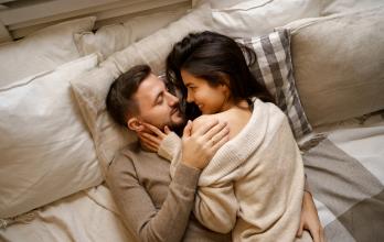beautiful-young-happy-couple-relaxing-in-bed-and-smiling-embracing