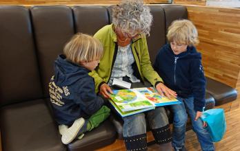 La abuela lee en voz alta un cuento a los niños