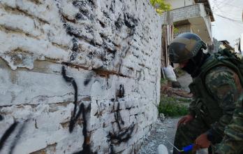 Militares trabajando en la limpieza de una de las paredes marcadas por la banda delictiva.