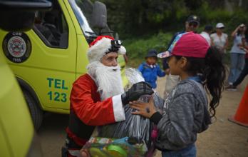 Un bombero cumple su tradicional y acrobática entrega de regalos de Navidad en Guatemala