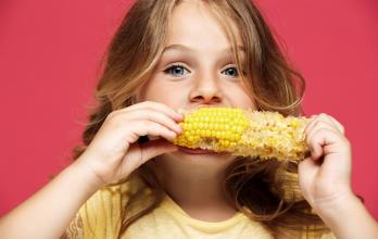 niña comiendo maíz