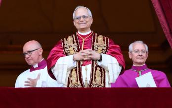 El recién elegido Papa León XIV (c), cardenal Robert Francis Prevost de EE.UU., sonríe desde la logia central de la Basílica de San Pedro, Ciudad del Vaticano.