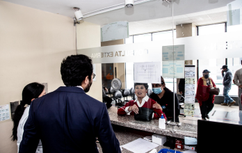 Édgar Lama (de espaldas), en la ventanilla de atención a los pacientes, en el Hospital de Riobamba.