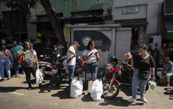 Personas esperan transporte público el 22 de diciembre de 2025, en Caracas (Venezuela).