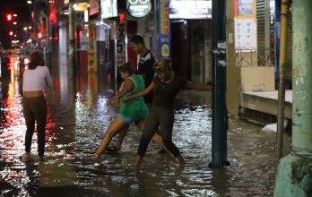 peatones en calles inundadas de Milagro nocturno