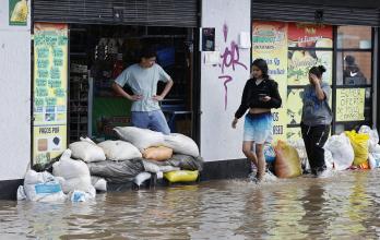 Personas usan sacos de arena para impedir que el agua entre a las casas