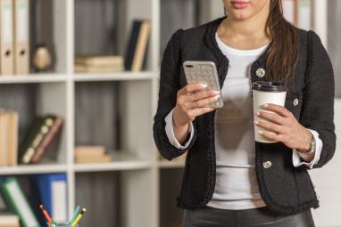 Ejecutiva con celular en mano