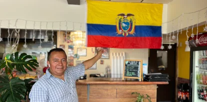 Segundo López posa con orgullo junto a la bandera tricolor que adorna su restaurante,