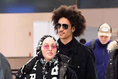 Madonna fue captada con su novio en el aeropuerto de Londres, donde despedirán el año.