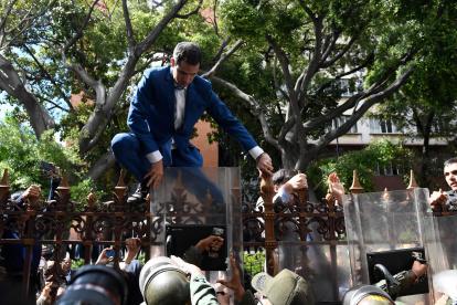 Guaidó intentó trepar las rejas del edificio legislativo, pero militares con escudos antimonines le impidieron saltar.